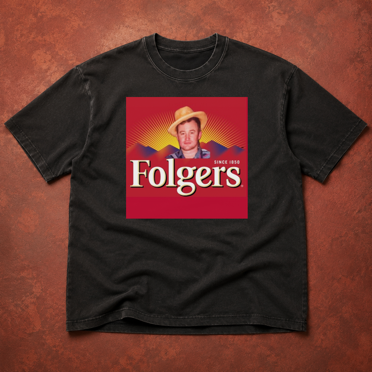 Washed black heavyweight T-shirt printed with Craig in a straw hat over a Folgers mountain label